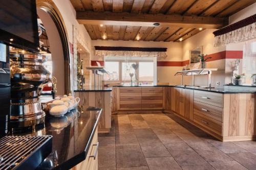 a large kitchen with wooden cabinets and a window at Hotel Hirschenstein in Achslach