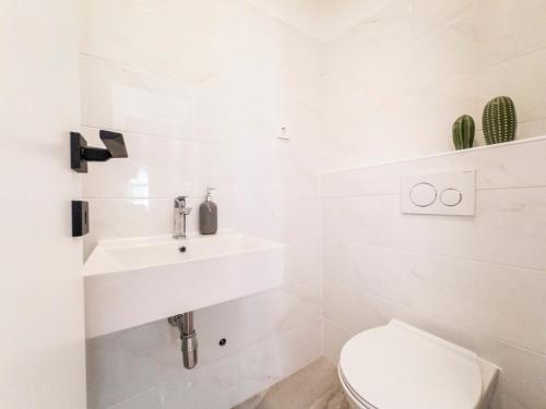 a white bathroom with a sink and a toilet at Casa Cappello in Hvar