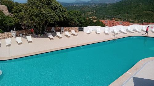 a large swimming pool with lounge chairs at Casa Turchese-Colline Costa Smeralda in Olbia