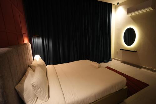 a bedroom with a white bed and a black curtain at 2BHK Serenity Suite By SkyPark One in Islamabad