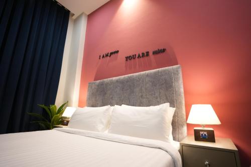 a bedroom with a white bed with a red wall at 2BHK Serenity Suite By SkyPark One in Islamabad