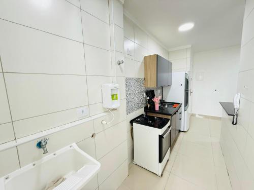 Refúgio Beira Mar Praia Grande في برايا جراندي: مطبخ أبيض مع حوض وموقد