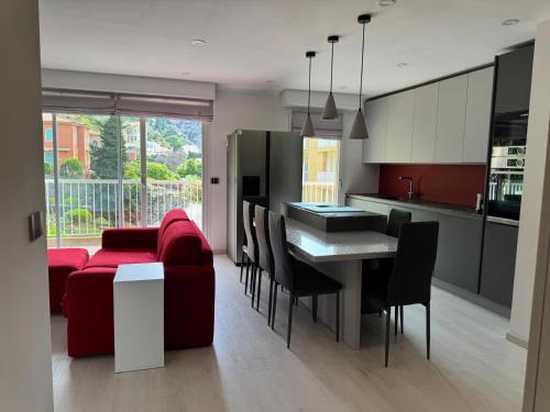 Il comprend une cuisine et un salon avec un canapé rouge et une table. dans l'établissement Ania, à Menton