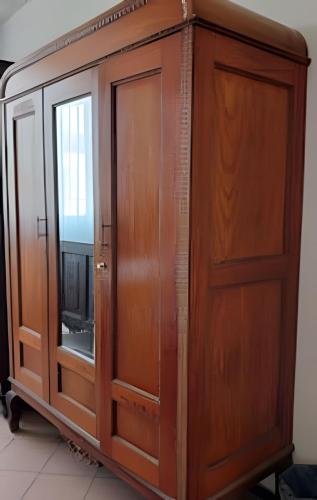 a wooden cabinet with a glass door next to a window at LA CASA de los RIVAS, AA, amplia, cómoda, céntrica in Tepic