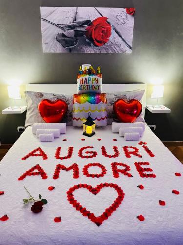 a bed with a happy birthday cake and hearts on it at Room24 Relax & Wellness in Genzano di Roma