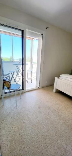 une chambre avec un lit et une vue sur un balcon dans l'établissement La Frégate Town Centre and Beach, au Grau-du-Roi