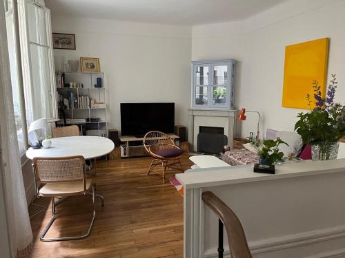 un salon avec une table et des chaises dans l'établissement Comme une petite maison, à Paris