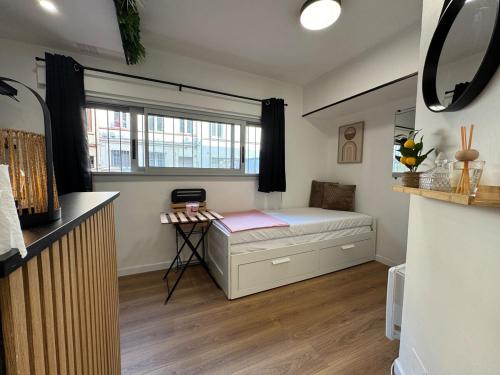 une petite chambre avec un lit et une fenêtre dans l'établissement Le Germier - Studio en hyper-centre de Toulouse, à Toulouse