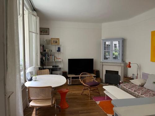 un salon avec une table et un canapé dans l'établissement Comme une petite maison, à Paris