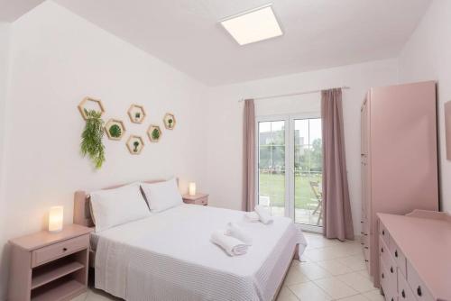 a white bedroom with two beds and a window at Casa Marjardin Hanioti 2025 in Hanioti