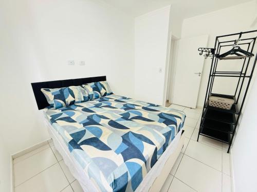 Refúgio Beira Mar Praia Grande في برايا جراندي: غرفة نوم بها سرير مع لحاف أزرق وأبيض