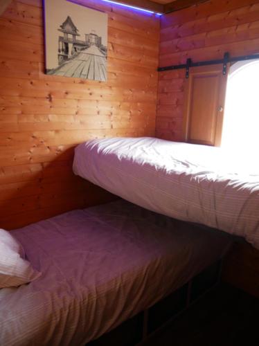 une chambre avec deux lits dans une cabane en rondins dans l'établissement La Grande Pêcherie, à Saint-Malo-de-Guersac