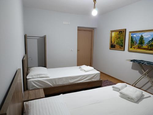 a bedroom with two beds and a mirror on the wall at Center apartment 2 in Shkodër