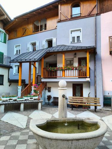 a building with a fountain in front of a building at Cà da Nello in Pellizzano