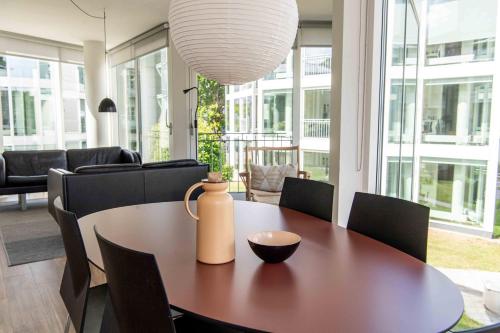 a dining room with a table and chairs and a vase on it at Kolding Hotel Apartments in Kolding