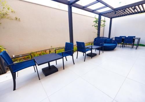 a group of blue tables and chairs on a patio at Urbà Home Stay by Housi in Goiânia