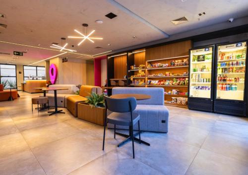 a lobby of a store with chairs and tables at Urbà Home Stay by Housi in Goiânia