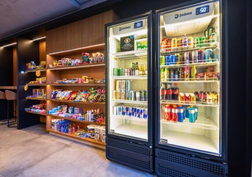 a refrigerator filled with lots of drinks in a store at Urbà Home Stay by Housi in Goiânia
