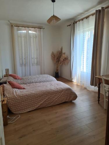 - une chambre avec un grand lit dans une pièce dotée de fenêtres dans l'établissement Maison Fabien et Justine, à Péronne