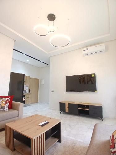 a living room with a couch and a coffee table at Studio Moderne avec Vue sur piscine et proche de la plage à Ocean Park Zenata Eco City in Aïn Harrouda