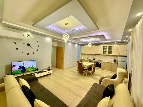 uma grande sala de estar com um sofá e uma televisão em Chloe Apartament em Berati