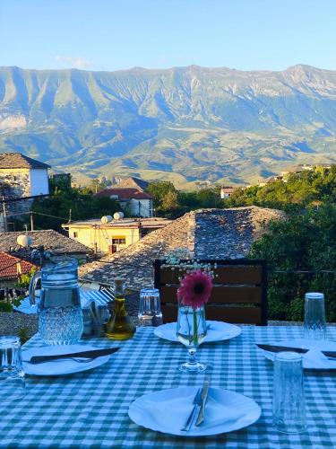 a table with a blue and white checkered table cloth at Guri Guesthouse in Gjirokastër