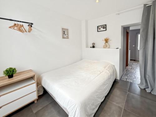 une chambre blanche avec un lit et une commode dans l'établissement Songe des Vagues Studio, à Criel-sur-Mer