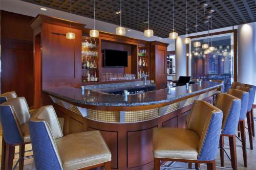 a bar in a restaurant with chairs and a tv at Hilton Garden Inn Portland Downtown Waterfront in Portland