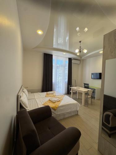a bedroom with a bed and a couch and a table at Nakashidze's Apartments in Batumi