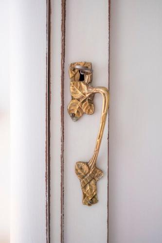 a door handle with a gold door knocker on a door at La Collina dei Conigli - immersi nella natura in Montebabbio