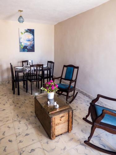 a dining room with chairs and a table with flowers at Hotel Boutique Flores y Gemas in Mérida