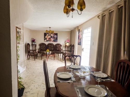 a dining room and living room with a table and chairs at Hotel Boutique Flores y Gemas in Mérida