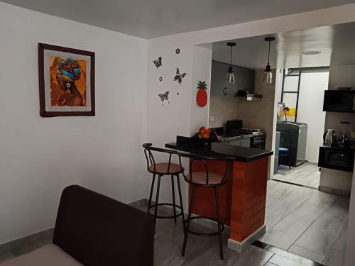 a kitchen with a bar in the corner of a room at Home Sweet Home Luxury Paipa in Paipa