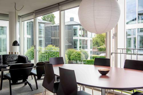 a dining room with a table and chairs and a large window at Kolding Hotel Apartments in Kolding
