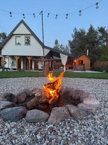 a fire pit in front of a house at Country house in Dziemiany