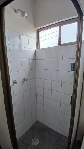 a bathroom with a shower with white tiled walls at SUITE Clavel, AA, cocineta, baño privado, ubicació in Tepic