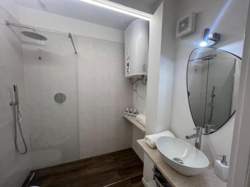 a bathroom with a sink and a shower with a mirror at New ! Rayuela San Pantaleo in San Pantaleo