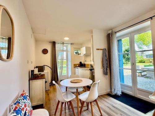 un salon avec une table et des chaises et une cuisine dans l'établissement Joli Cocon au Cœur de la Petite Cité de Caractère, à La Celle-sous-Gouzon