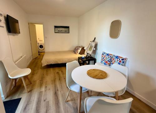 une pièce avec une table, des chaises et un lit dans l'établissement Joli Cocon au Cœur de la Petite Cité de Caractère, à La Celle-sous-Gouzon