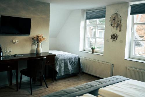 a bedroom with a desk and a bed and a bed and window at Ostsee Hotel Travemünde in Travemünde