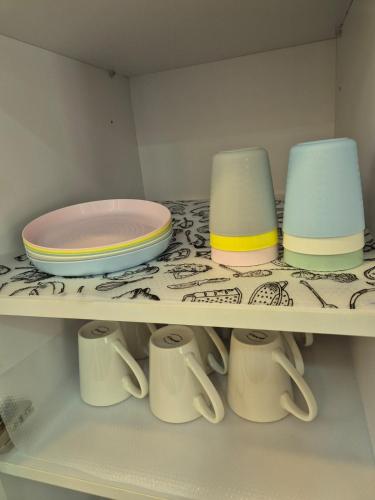 a shelf with plates and cups on it at The Urban EcoLuxe Karen, Nairobi in Nairobi