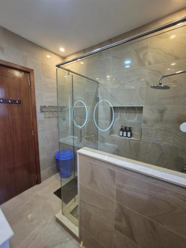 a bathroom with a glass shower with two mirrors at The Urban EcoLuxe Karen, Nairobi in Nairobi
