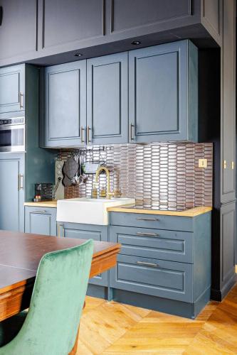 une cuisine avec des placards bleus et une table en bois dans l'établissement Otentik & Chic, à Metz