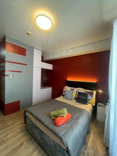 a bedroom with a bed with a red wall at Stylish Urban in Central Location with 500Mbps WiFi and Private Parking in Bacolod