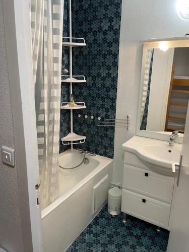 a bathroom with a sink and a tub and a toilet and a mirror at Gourette Euroneige Pied de piste - 6 personnes in Eaux-Bonnes