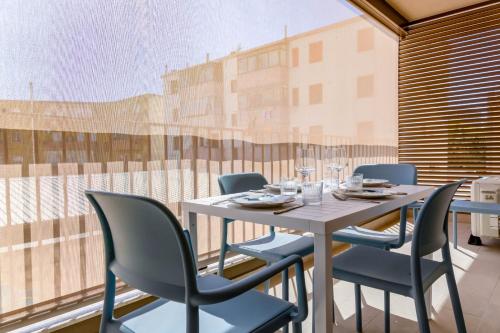 a table and chairs in a room with a large window at Blu Lodge Guest House in Alghero
