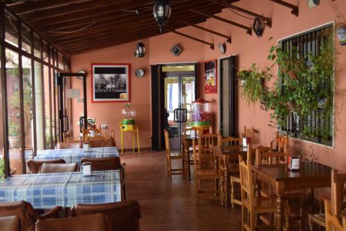 een restaurant met tafels en stoelen en roze muren bij Hotel Río Seco in Pedrera