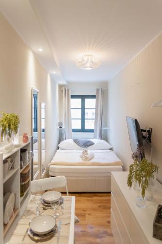 a white bedroom with a bed and a table at Ferienwohnung Baltic in Barth