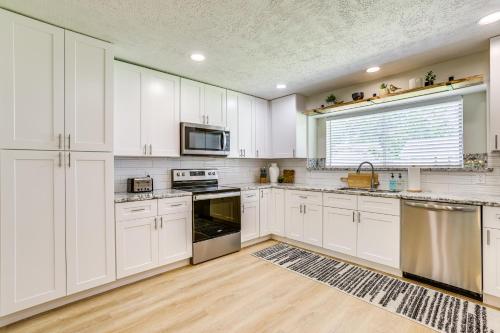 a kitchen with white cabinets and stainless steel appliances at 5 Mi to Lake Houston Family Home in Humble in Humble