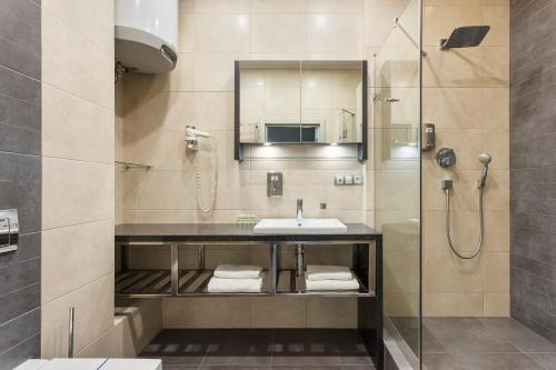 a bathroom with a sink and a shower at Odesa Pearl Apartments in Odesa